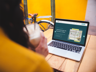 over-shoulder-mockup-of-a-woman-using-a-macbook-on-a-wooden-table-a19521